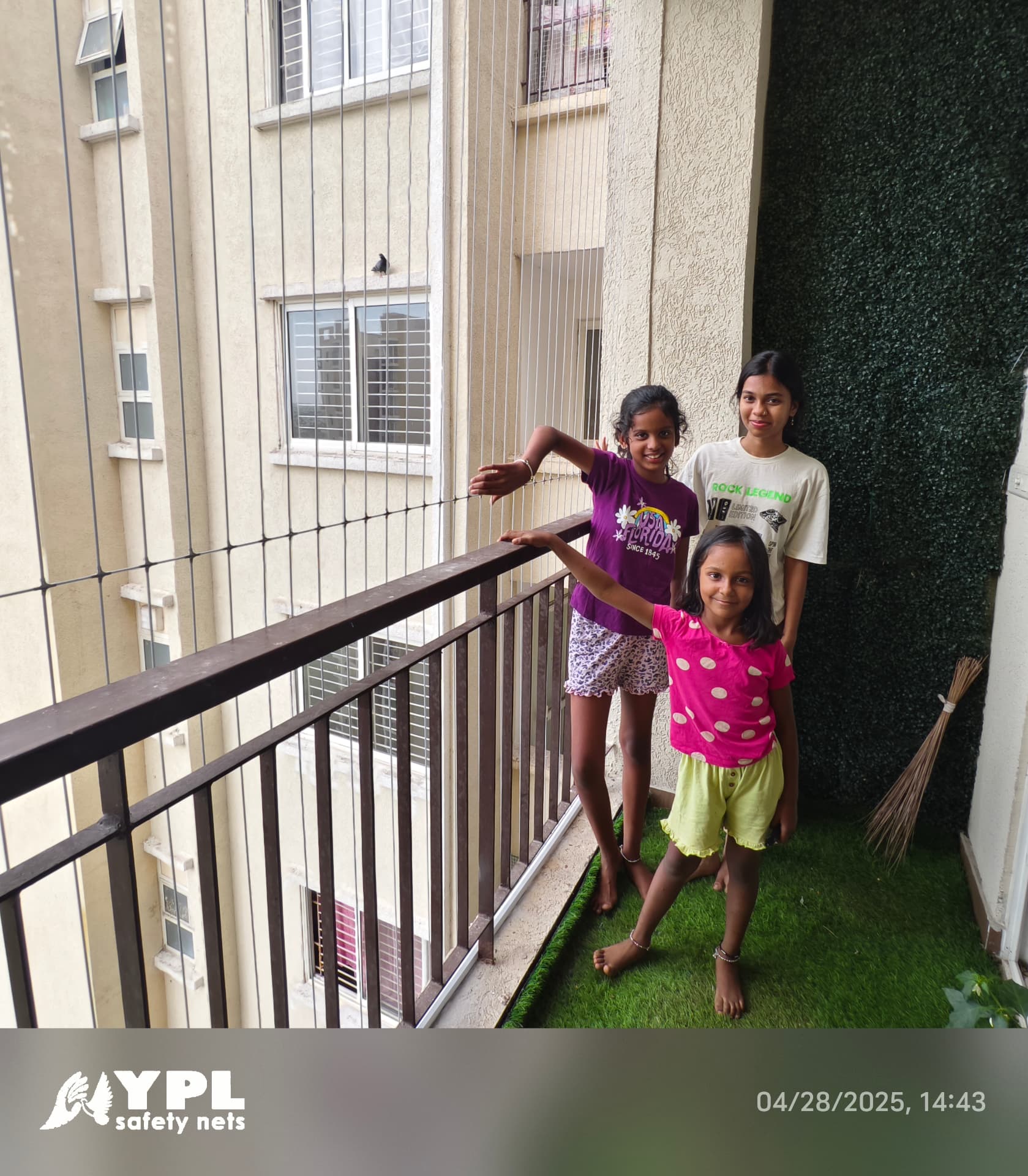 Children standing safely on a balcony protected by vertical invisible grill cables, with the YPL Safety Nets logo.